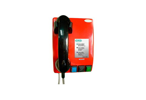 Intercomunicador com a base vermelha, telefone preto e cabo metálico com três botões, que dá esquerda para a direito são: azul, preto e verde.